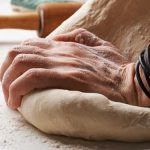 hands kneeling bread into shape