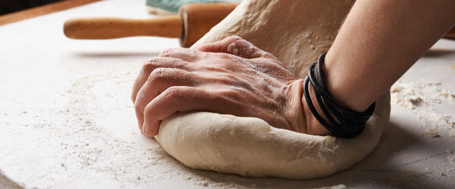 hands kneeling bread into shape